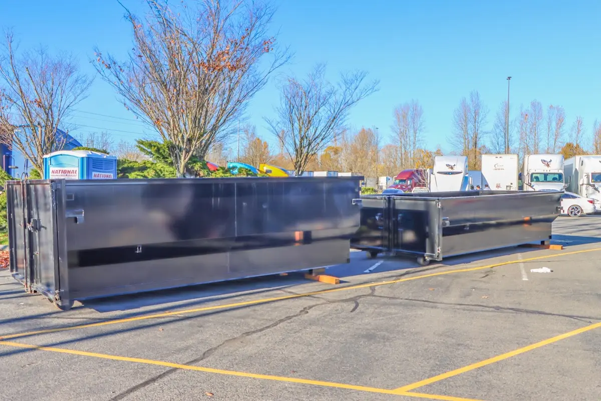 Professional dumpster rental service with roll-off container on residential driveway in Brownfields